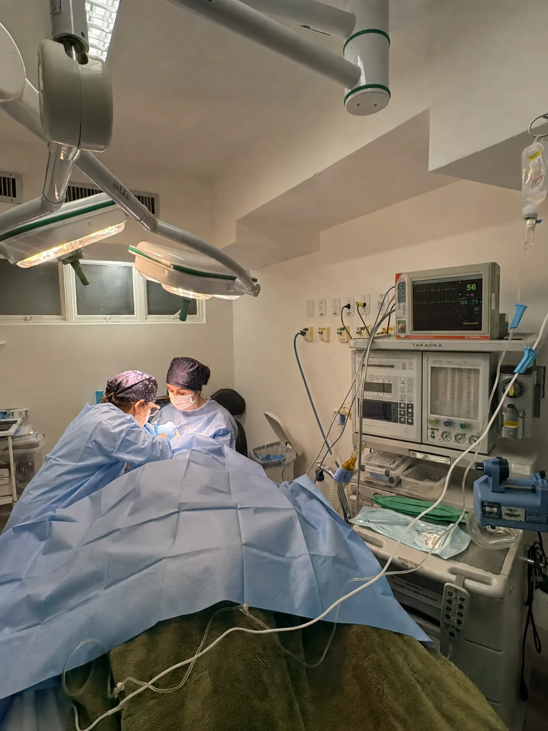 Equipe médica realizando procedimento em centro cirúrgico com monitorização